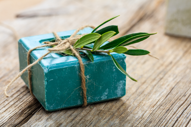 Kleine blaue Box mit einer gr&uuml;nen Pflanze, repr&auml;sentiert die Naturkosmetik Geschenk- und Reisesets von Macrovita &amp; Olive-elia